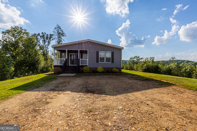 view of front of property featuring a front yard and covered porch