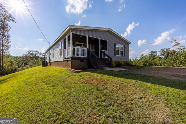 view of front of home featuring a front lawn and central AC