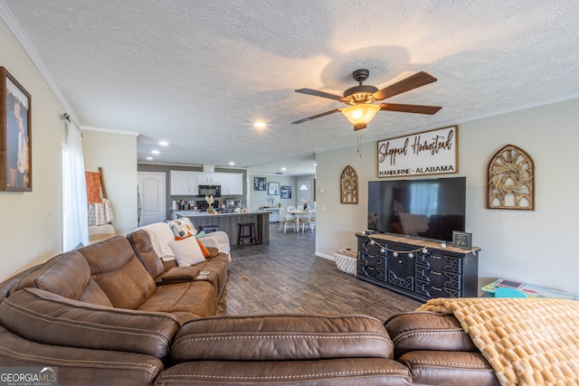 living room with ceiling fan, a textured ceiling, dark hardwood / wood-style floors, and ornamental molding