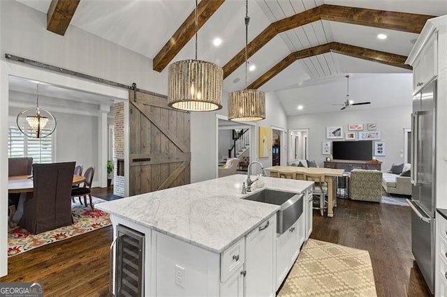 kitchen with white cabinets, sink, beverage cooler, ceiling fan with notable chandelier, and a barn door