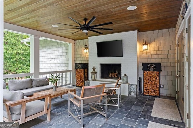 view of patio / terrace with an outdoor living space with a fireplace and ceiling fan