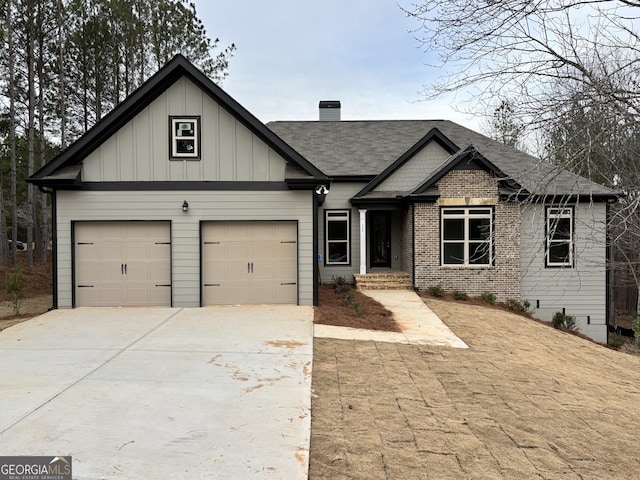 5544 Whispering Swan Ct, Douglasville, GA 30135 - view of front of property with driveway, board and batten siding, a garage, a chimney, and roof with shingles