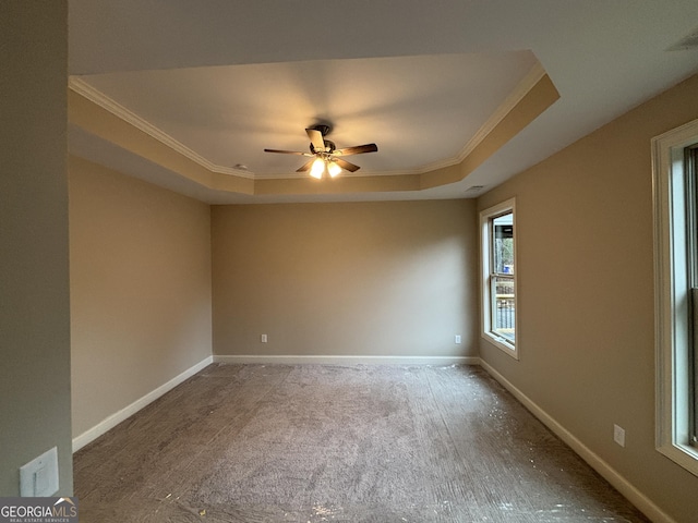 unfurnished room with carpet floors, a raised ceiling, ceiling fan, and crown molding