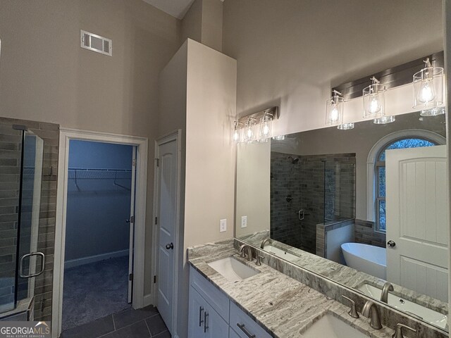 5544 Whispering Swan Ct, Douglasville, GA 30135 - full bath with a stall shower, tile patterned flooring, a freestanding tub, a spacious closet, and double vanity