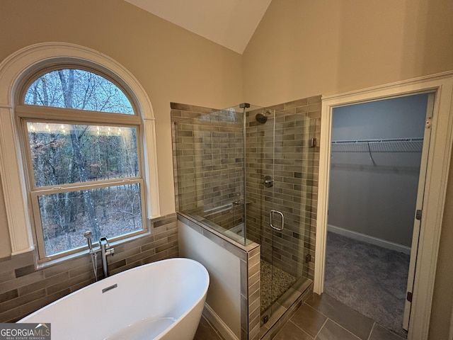 5544 Whispering Swan Ct, Douglasville, GA 30135 - full bathroom with a stall shower, tile patterned flooring, a freestanding tub, vaulted ceiling, and a walk in closet