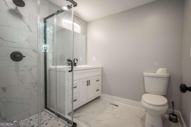 bathroom with an enclosed shower, vanity, and toilet