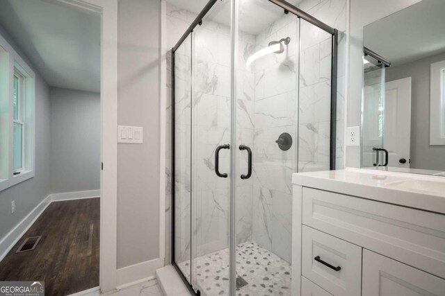 bathroom featuring vanity, hardwood / wood-style flooring, and a shower with door