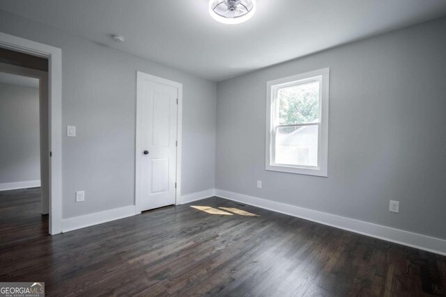 unfurnished room with dark hardwood / wood-style floors