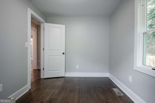 unfurnished room featuring dark wood-type flooring