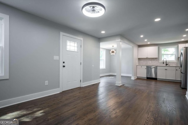 foyer with dark hardwood / wood-style floors, sink, and a chandelier