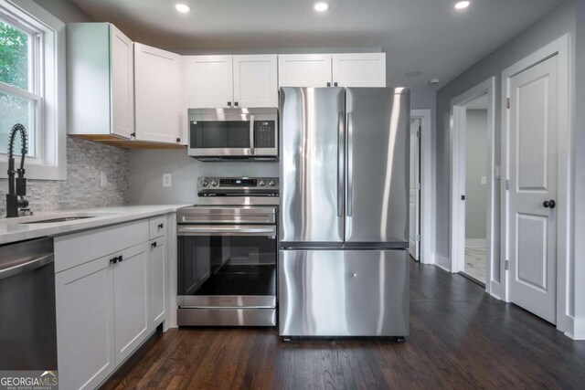 kitchen with white cabinets, dark hardwood / wood-style flooring, and appliances with stainless steel finishes