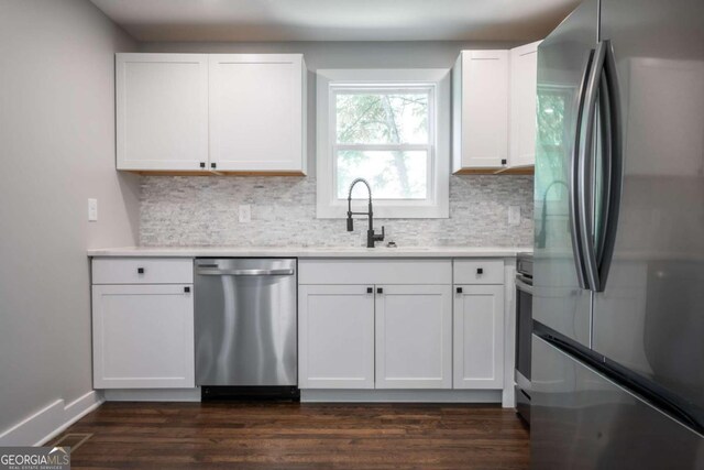 kitchen featuring stainless steel appliances, decorative backsplash, sink, dark hardwood / wood-style floors, and white cabinetry