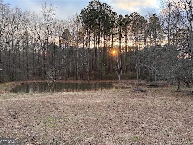 yard at dusk featuring a water view