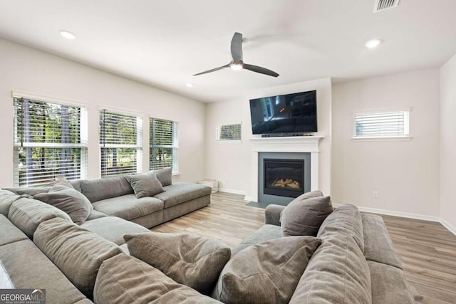 living room with light wood-type flooring and ceiling fan