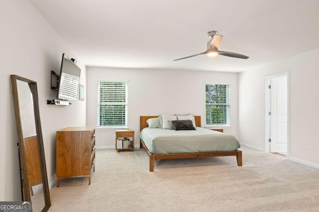 carpeted bedroom with multiple windows and ceiling fan