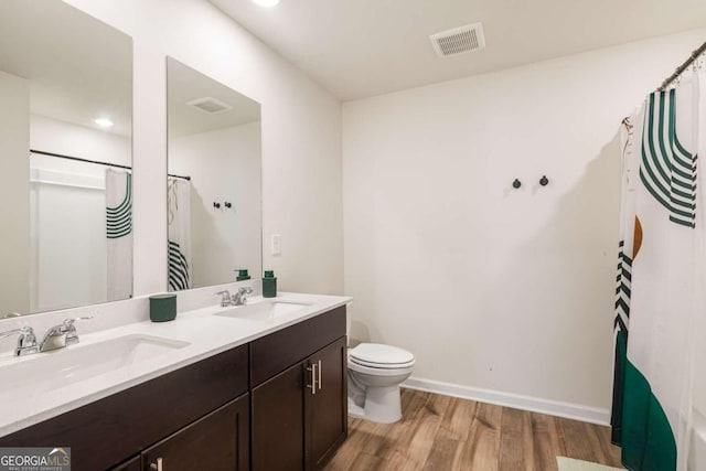 bathroom featuring vanity, hardwood / wood-style flooring, toilet, and a shower with shower curtain