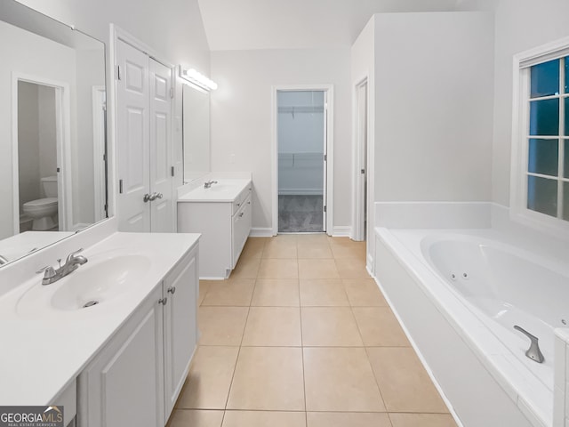 bathroom with tile patterned floors, a bath, vanity, and toilet