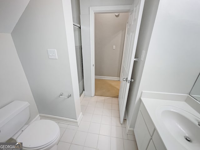 bathroom featuring tile patterned floors, a shower with door, vanity, and toilet