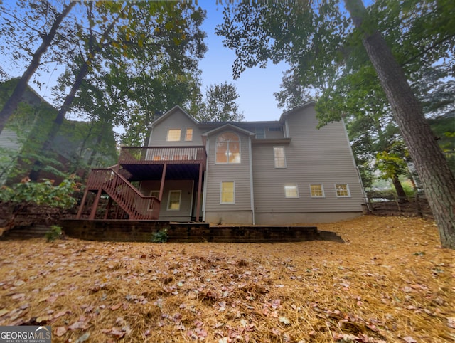 rear view of house featuring a wooden deck