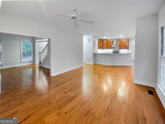 unfurnished living room featuring light hardwood / wood-style floors and ceiling fan