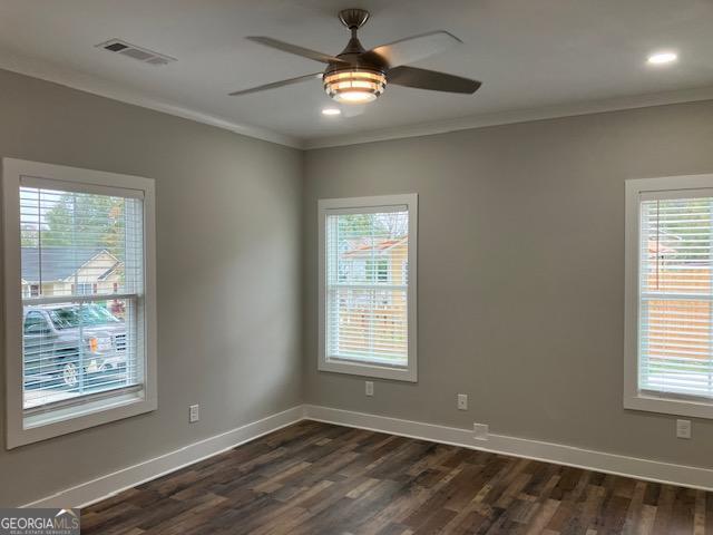 empty room featuring ornamental molding, dark hardwood / wood-style floors, and ceiling fan