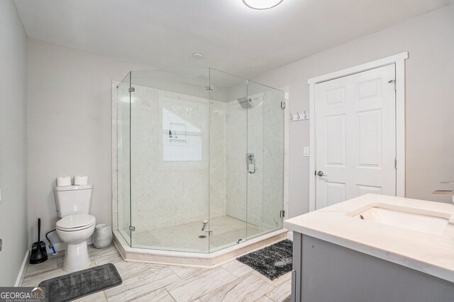 bathroom with vanity, toilet, and a shower with shower door