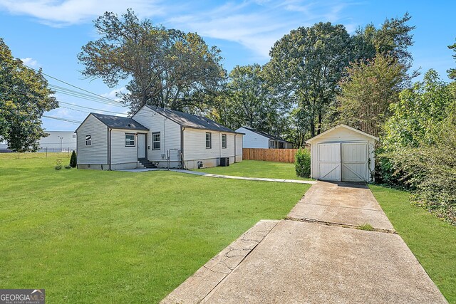 back of property featuring a yard and a storage unit