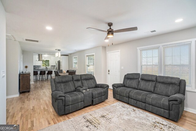 living room with ceiling fan and light wood-type flooring