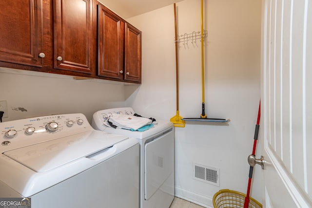 laundry area with cabinets, separate washer and dryer, and light tile patterned flooring