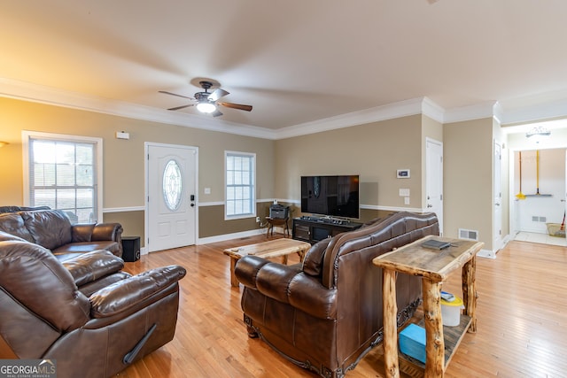 living room featuring ceiling fan, ornamental molding, and light hardwood / wood-style flooring