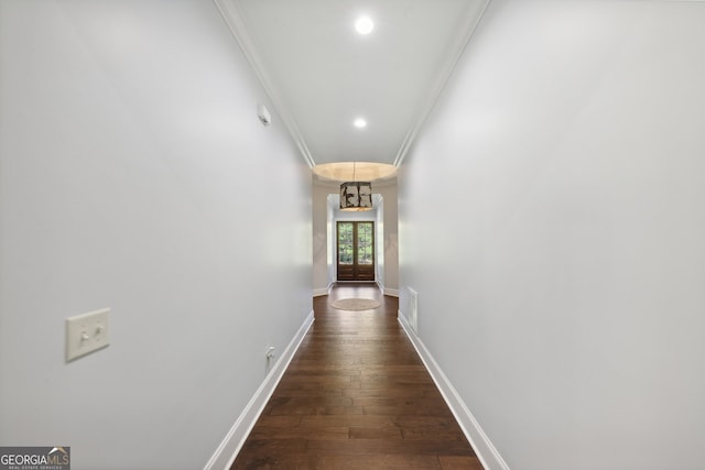 hallway featuring dark hardwood / wood-style flooring, a chandelier, and crown molding