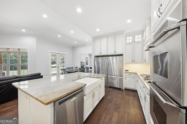 kitchen with white cabinets, appliances with stainless steel finishes, a center island with sink, and dark hardwood / wood-style flooring