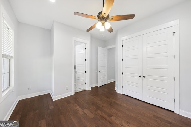 unfurnished bedroom featuring ceiling fan, a closet, and dark hardwood / wood-style flooring