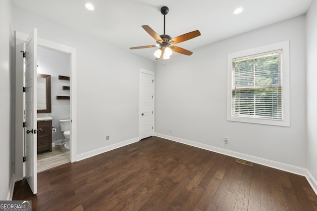 unfurnished bedroom with dark wood-type flooring, ceiling fan, and ensuite bathroom