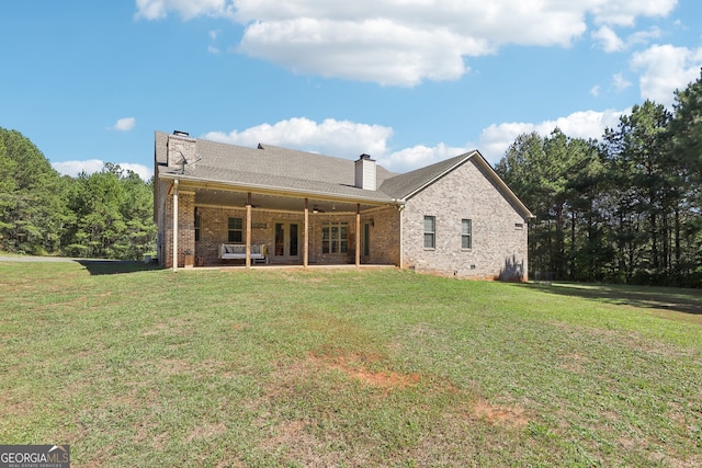 rear view of house featuring a lawn, ceiling fan, and a patio area