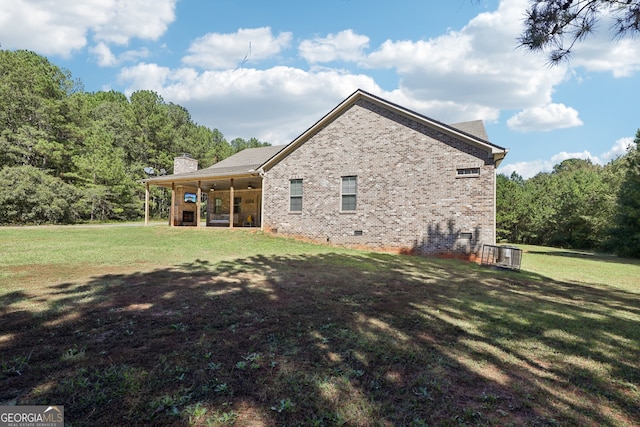 rear view of house featuring a lawn and ceiling fan