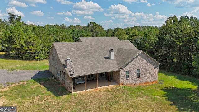 back of property with a patio area and a lawn