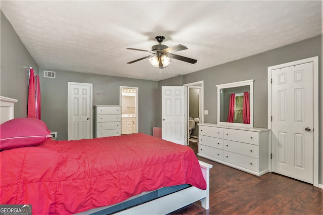 bedroom with ceiling fan, dark hardwood / wood-style floors, ensuite bathroom, and a textured ceiling