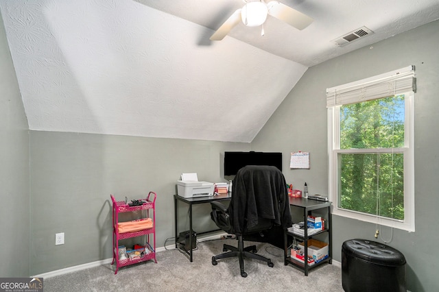 carpeted home office featuring vaulted ceiling, ceiling fan, and a textured ceiling