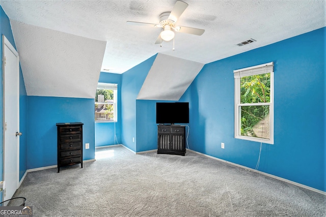 bonus room featuring a wealth of natural light, vaulted ceiling, ceiling fan, and a textured ceiling