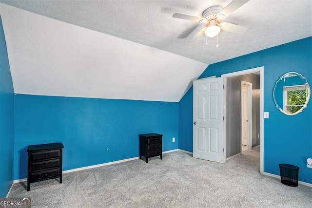 bonus room featuring a textured ceiling, carpet, vaulted ceiling, and ceiling fan