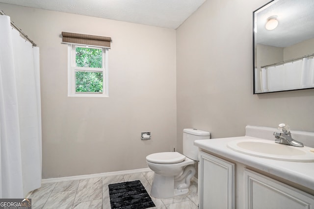 bathroom with vanity, toilet, and a textured ceiling