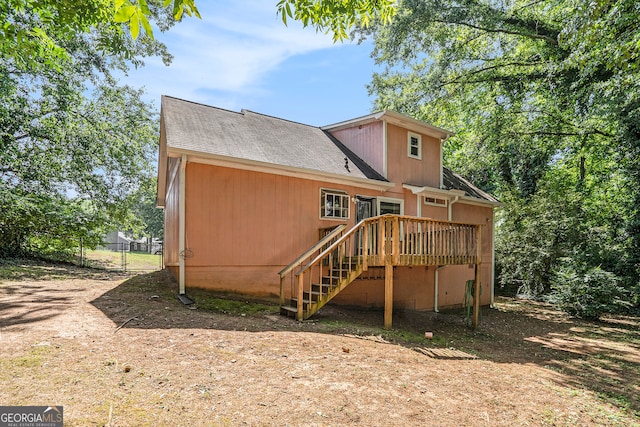 rear view of property featuring a wooden deck