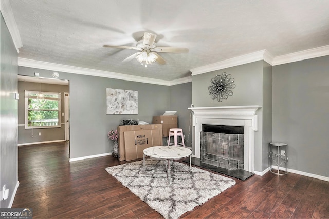 interior space featuring ceiling fan, ornamental molding, a textured ceiling, and dark wood-type flooring