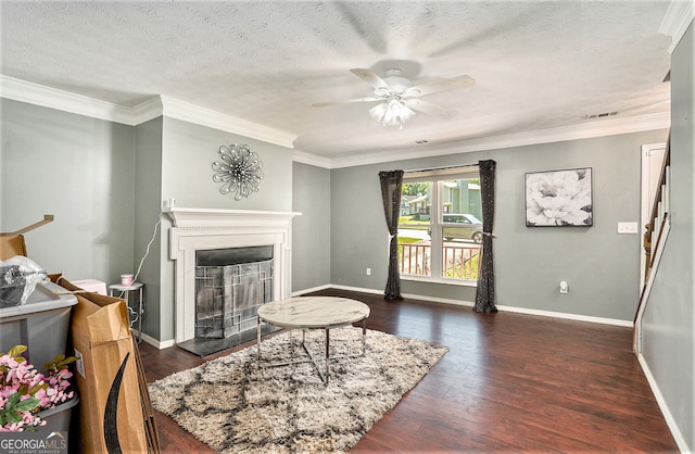 living room with ornamental molding, a textured ceiling, dark hardwood / wood-style floors, and ceiling fan