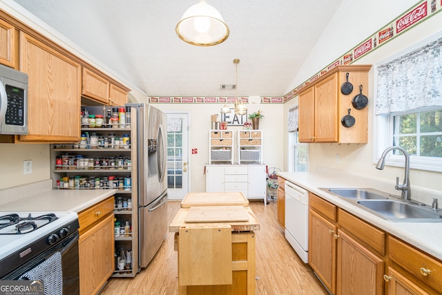 kitchen featuring pendant lighting, sink, lofted ceiling, butcher block counters, and appliances with stainless steel finishes