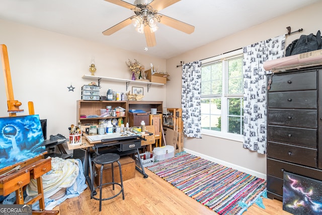 home office featuring light hardwood / wood-style flooring and ceiling fan