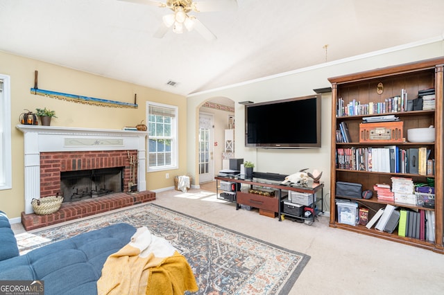 living room with carpet floors, lofted ceiling, ceiling fan, and a brick fireplace