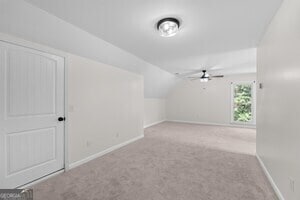 bonus room featuring vaulted ceiling and light carpet