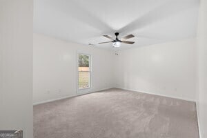 bathroom with ceiling fan, walk in shower, vanity, and toilet